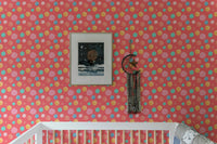Kids wallpaper with red and yellow dots in a nursery with a white cot.