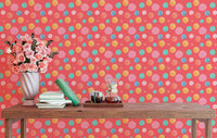 Abstract circle wallpaper mural behind a desk with pink flowers and books.