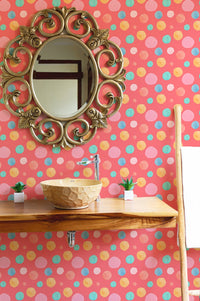 Polka dot wallpaper used in a bathroom setting with a round wooden mirror.