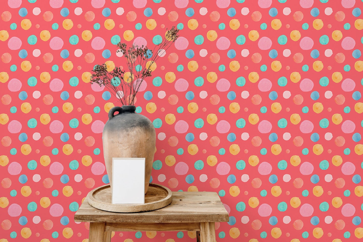 Multicolor wallpaper with round shapes behind a small wooden side table.