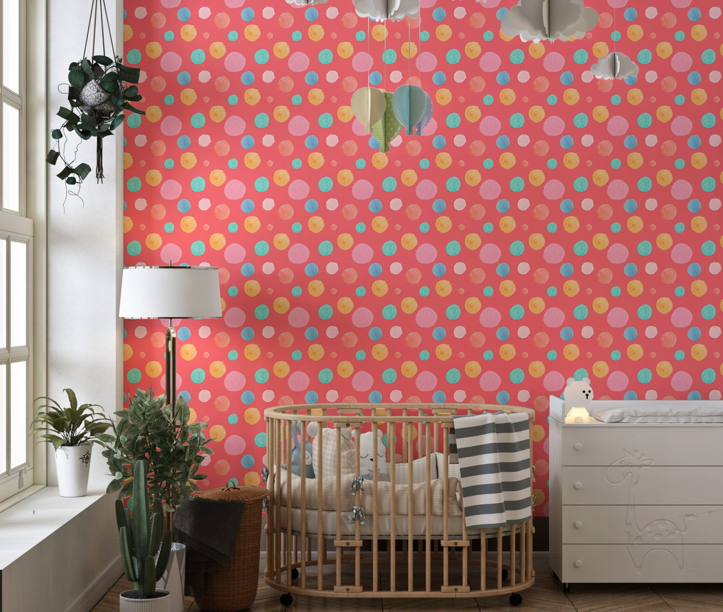 Playful dots wallpaper in a nursery room with a wooden crib and white lamp.