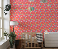 Playful dots wallpaper in a nursery room with a wooden crib and white lamp.