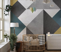 Modern triangle wall mural in a nursery with a wooden cot.