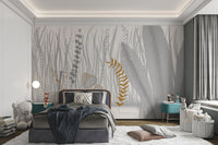 Abstract botanical wall mural with grey and gold leaf patterns in a bedroom.