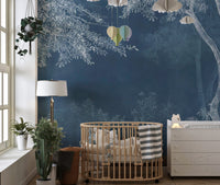 Indigo forest wall mural behind a wooden crib in a nursery with natural light.
