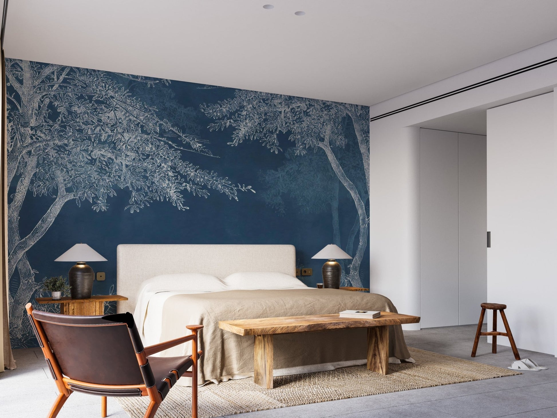 Dark blue indigo forest wall mural in a master bedroom with a wooden bench.
