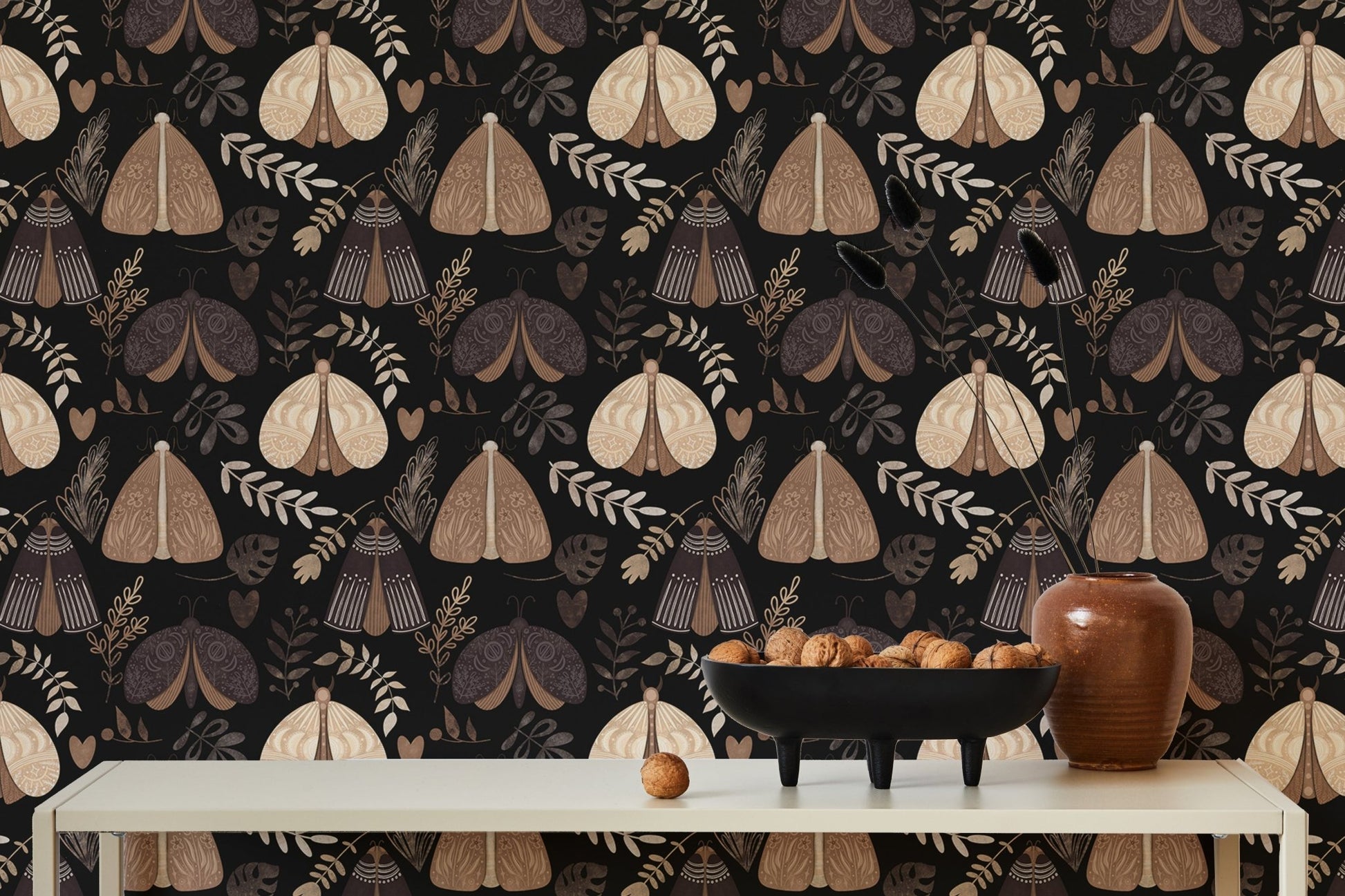 Symmetrical moth wallpaper on a dining room wall with white table and vases.