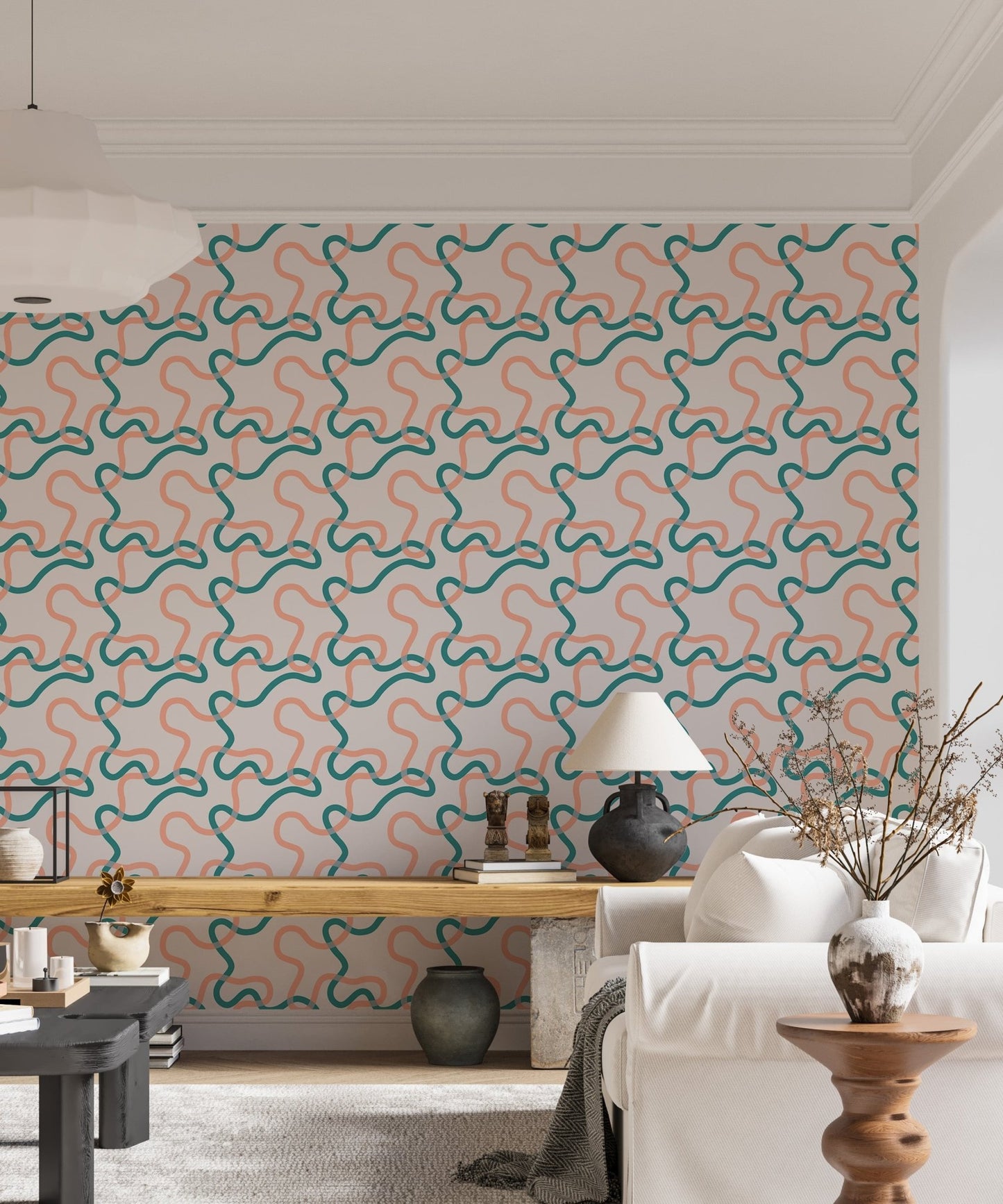 Wallpaper with teal and peach line squiggles behind a white sideboard and indoor plants.