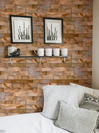 Textured stone wallpaper in a bedroom setting with white pillows and wall frames.
