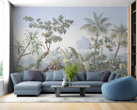 Large scale jungle wall mural behind a blue sectional sofa in living area.
