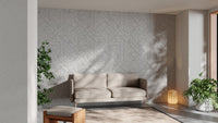 Neutral tone cityscape wallpaper in a living area with a tan leather couch.