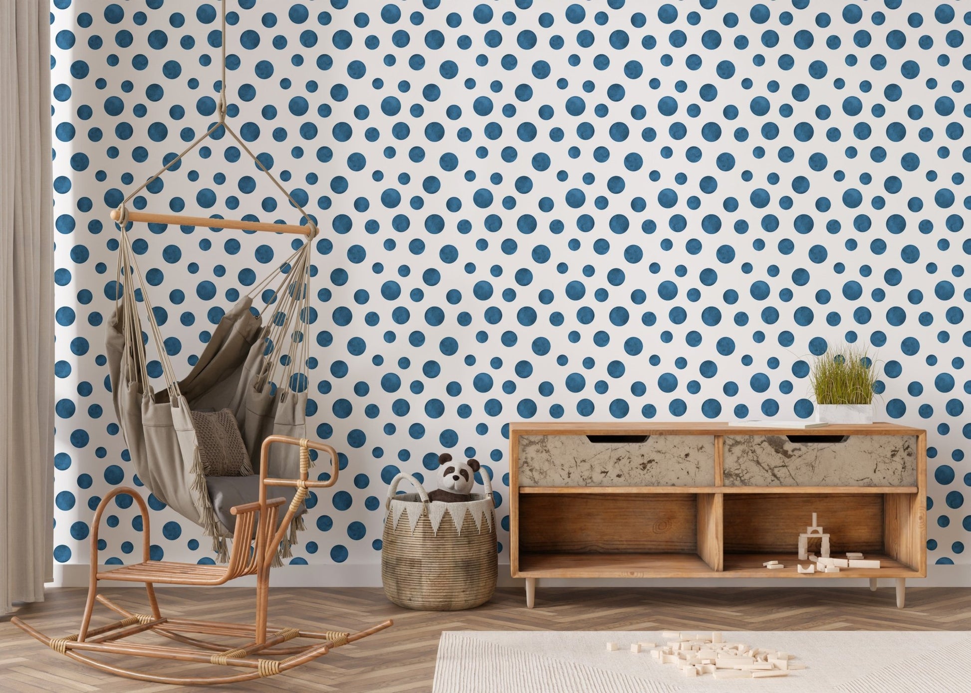 Indigo polka dot wallpaper in a nursery area with a wooden rocking chair.