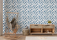 Indigo polka dot wallpaper in a nursery area with a wooden rocking chair.