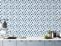 Indigo dotted wallpaper applied to a kitchen backsplash area with white cabinets.