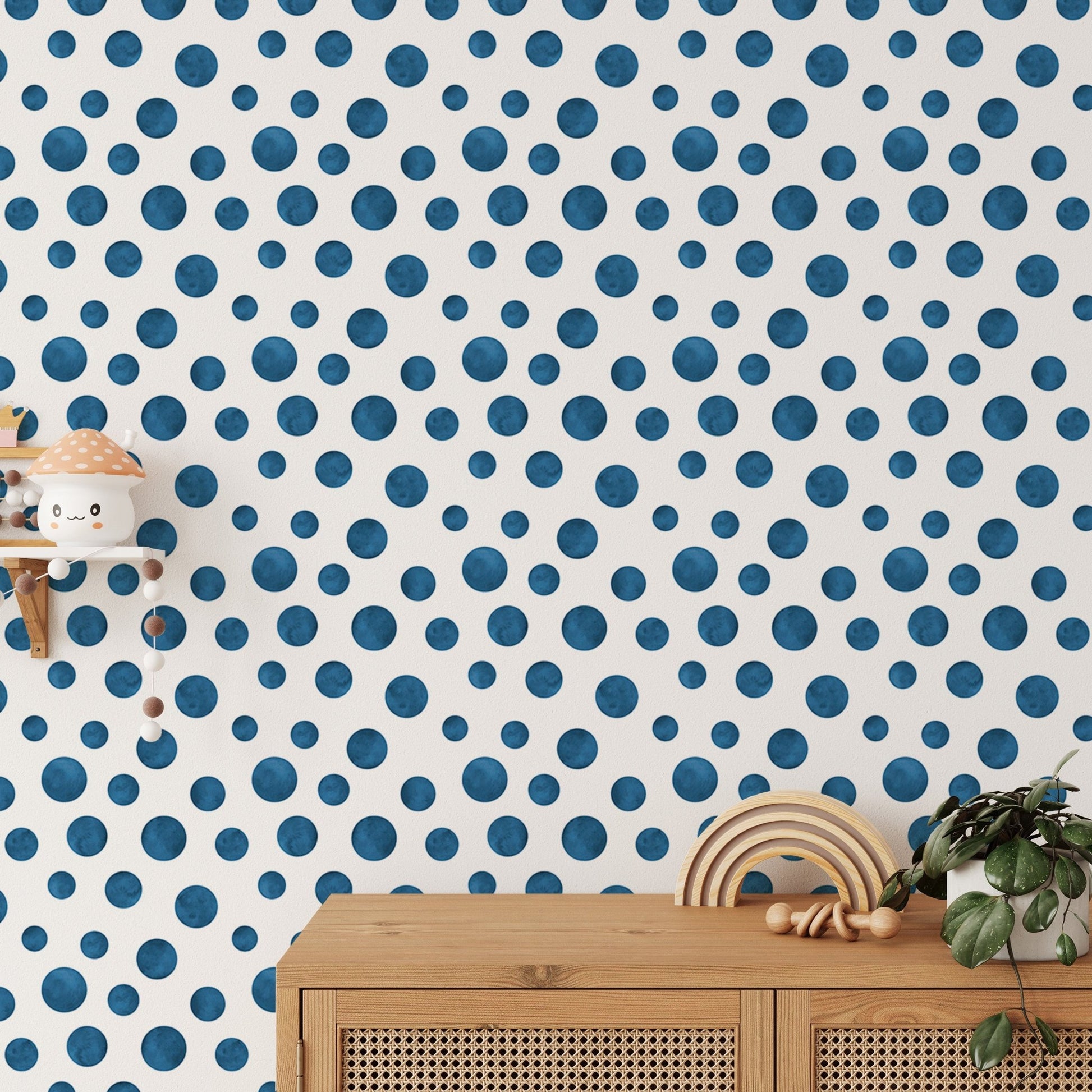 Navy Blue Indigo Watercolor Polka Dots Wallpaper behind a wooden sideboard and plants.