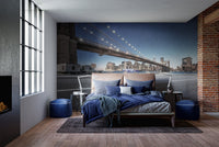 Manhattan skyline wall mural in a modern bedroom with blue bedding and wooden floors.
