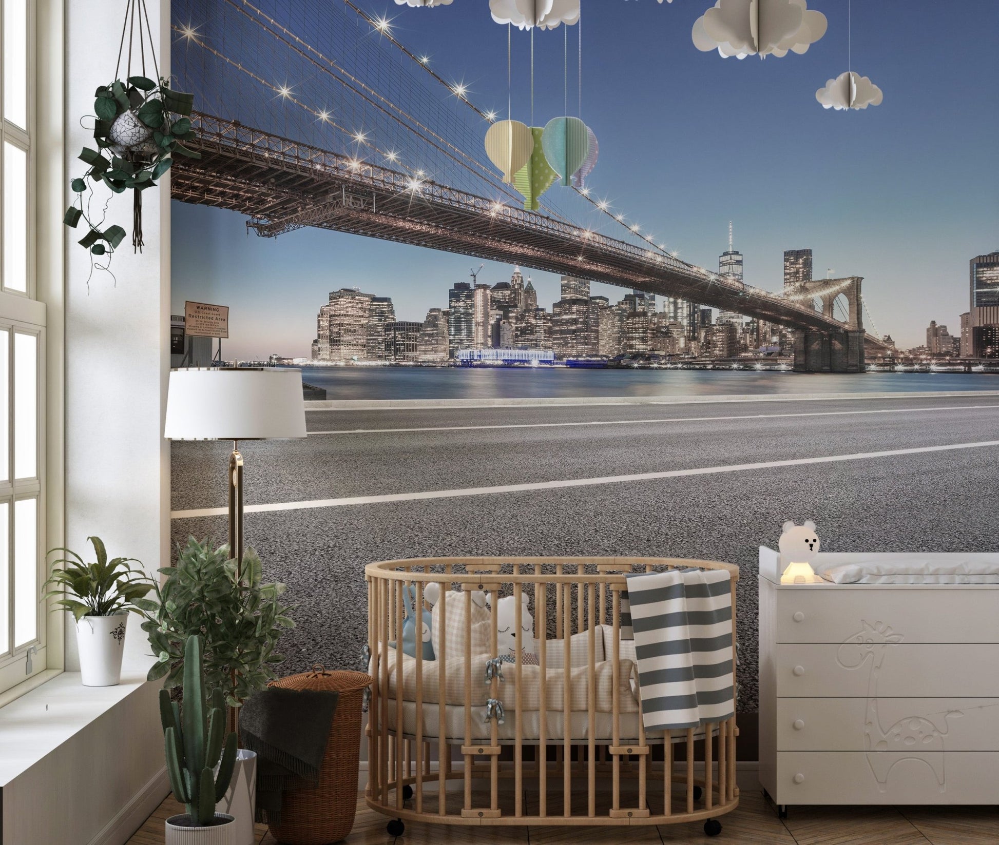 Cityscape manhattan wall mural for a nursery featuring a wooden crib and neutral decor.