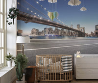 Cityscape manhattan wall mural for a nursery featuring a wooden crib and neutral decor.