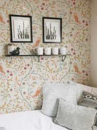 Light flower wallpaper with bird and leaf motifs in a living area with wall frame.