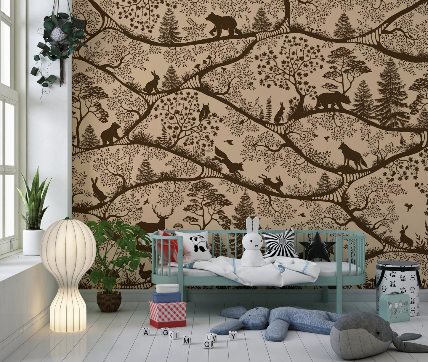 Brown forest wall mural with bears and deer in a modern nursery with a blue crib.