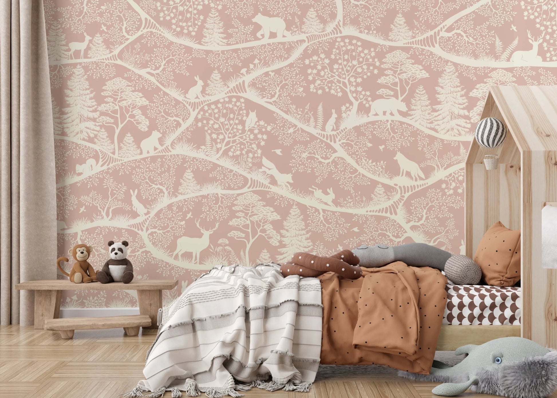 Detailed pink woodland animal wall mural behind a rustic wooden toddler bed.