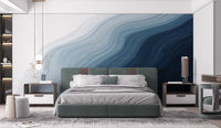 Dark to light blue wallpaper mural with fluid coastal pattern.