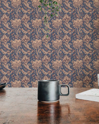 Textured floral wallpaper behind wooden table with black ceramic mug.