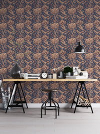 Retro floral wallpaper in home office with wooden desk and black lamp.