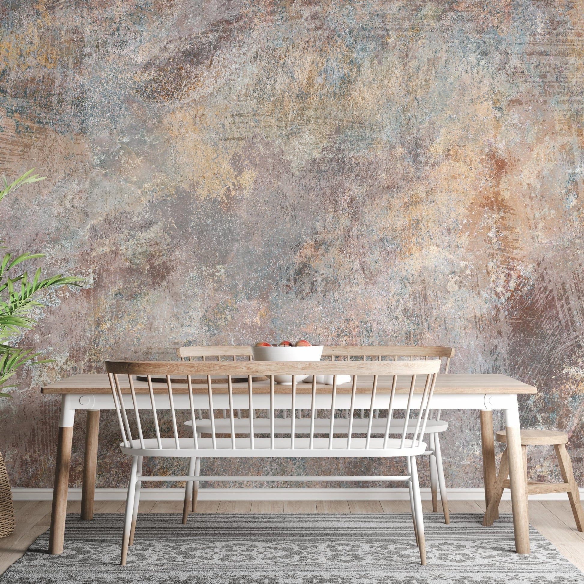 Rustic stone wall mural behind a wooden dining table and white bench in a home.
