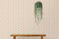 Hanging plant against a flecked illustration wall mural on a flat wall.