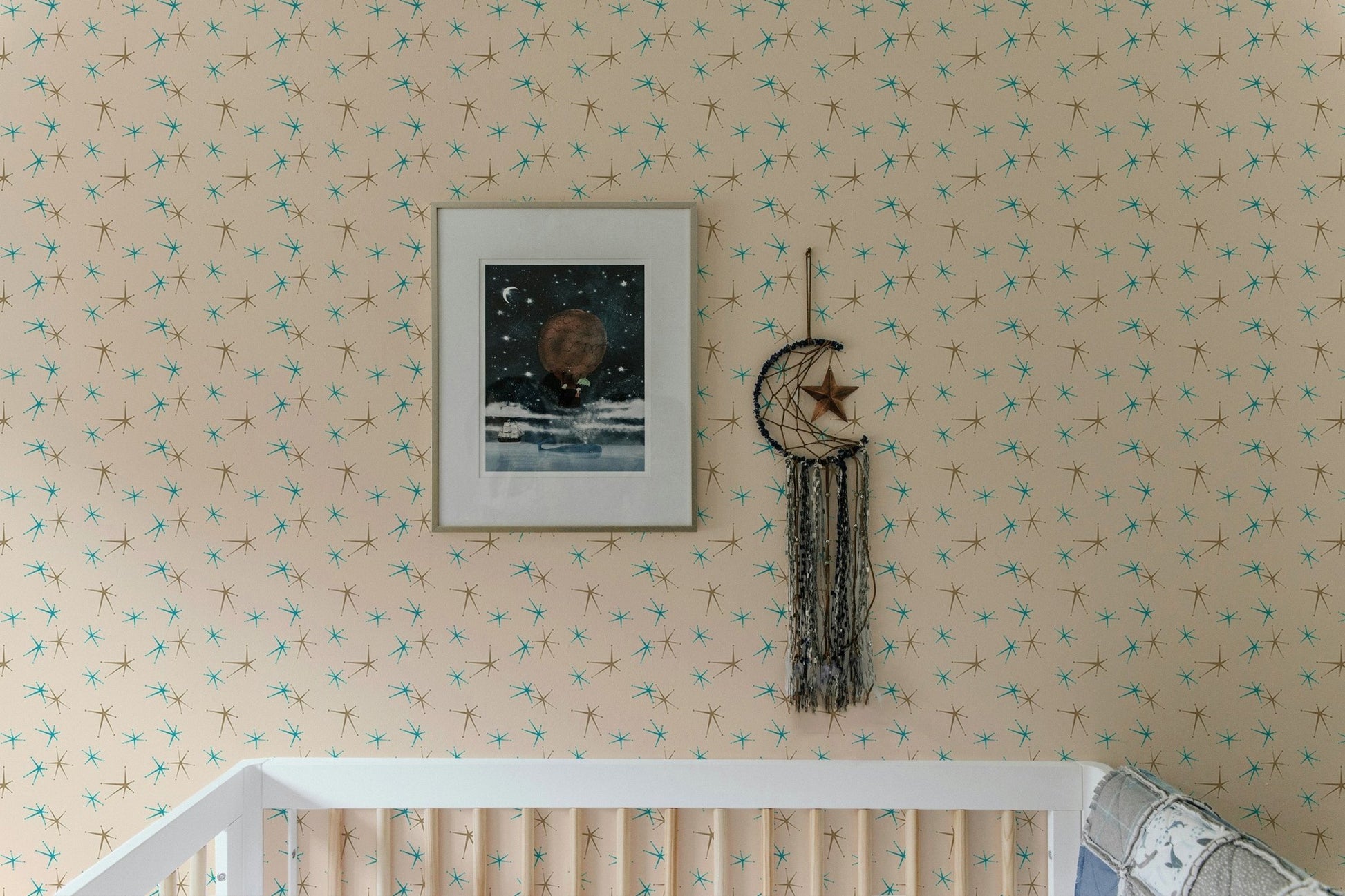 Nursery wall with framed art and old snow fleck illustration mural.