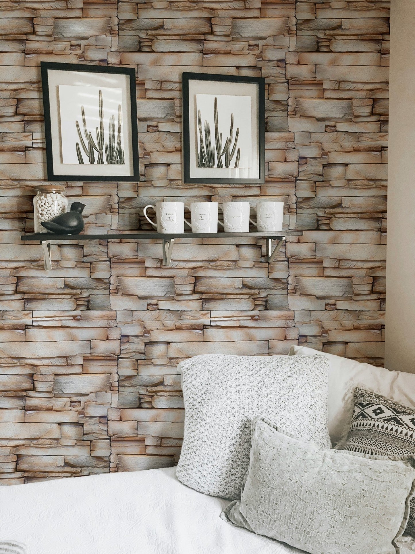 Sandstone wallpaper behind a bed with framed botanical art on the wall.