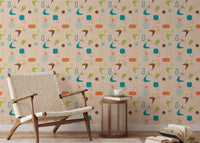 Reading area featuring a woven armchair against a vintage atomic pattern wall mural.