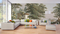 Landscape village wall mural with large green trees and white sofa in modern living area.