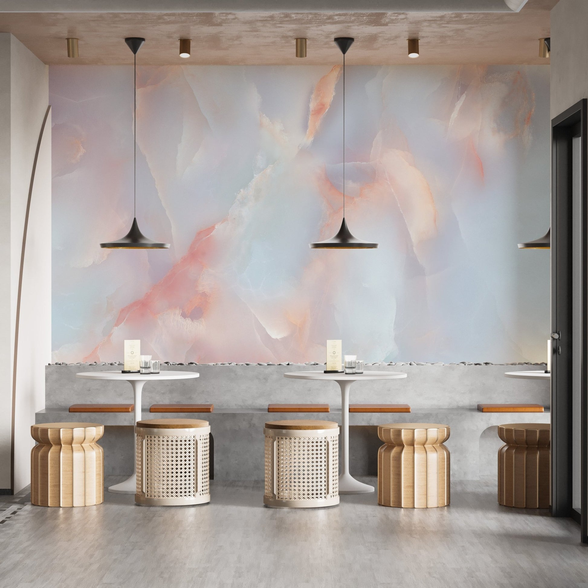 Marble wall mural in a cafe seating area with wooden stools and pendant lights.