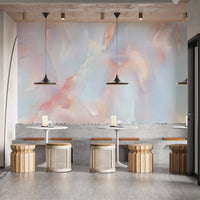 Marble wall mural in a cafe seating area with wooden stools and pendant lights.