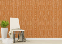 Minimalist geometric wallpaper behind a wooden chair with green plants.