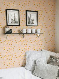 Geometric wall mural in a bedroom featuring white bedding and grey pillows.