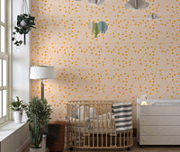 Nursery wall mural with orange starburst design near a wooden crib.