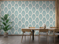 Ornamental damask wallpaper in a dining room with a large wooden table.