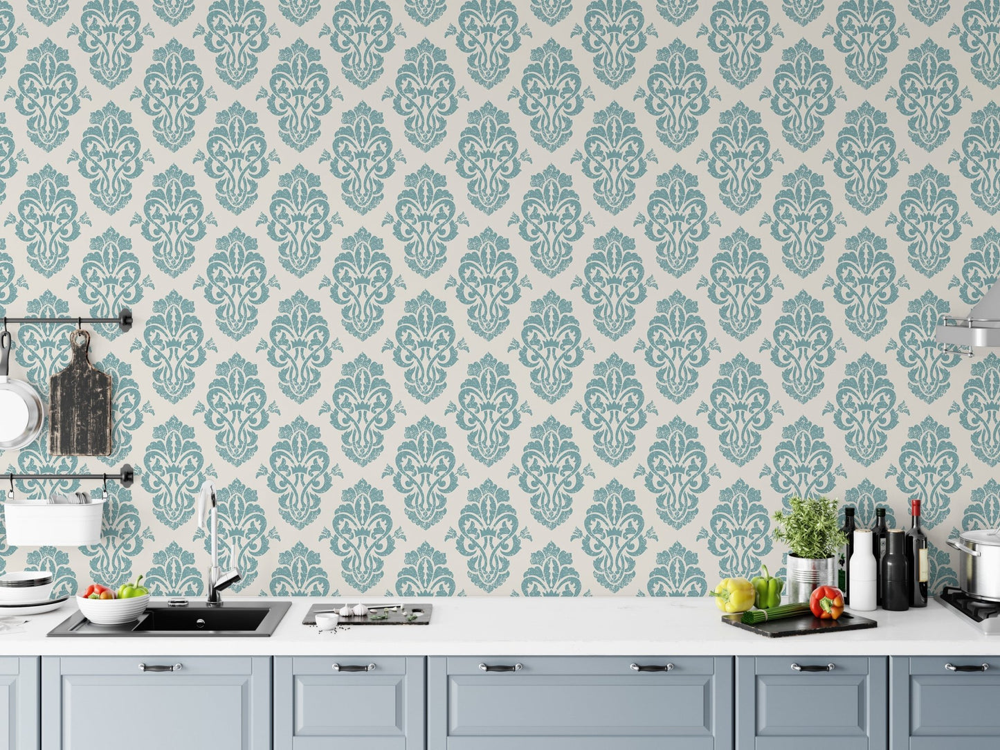 Teal and white damask wallpaper in a modern kitchen behind white cabinets.