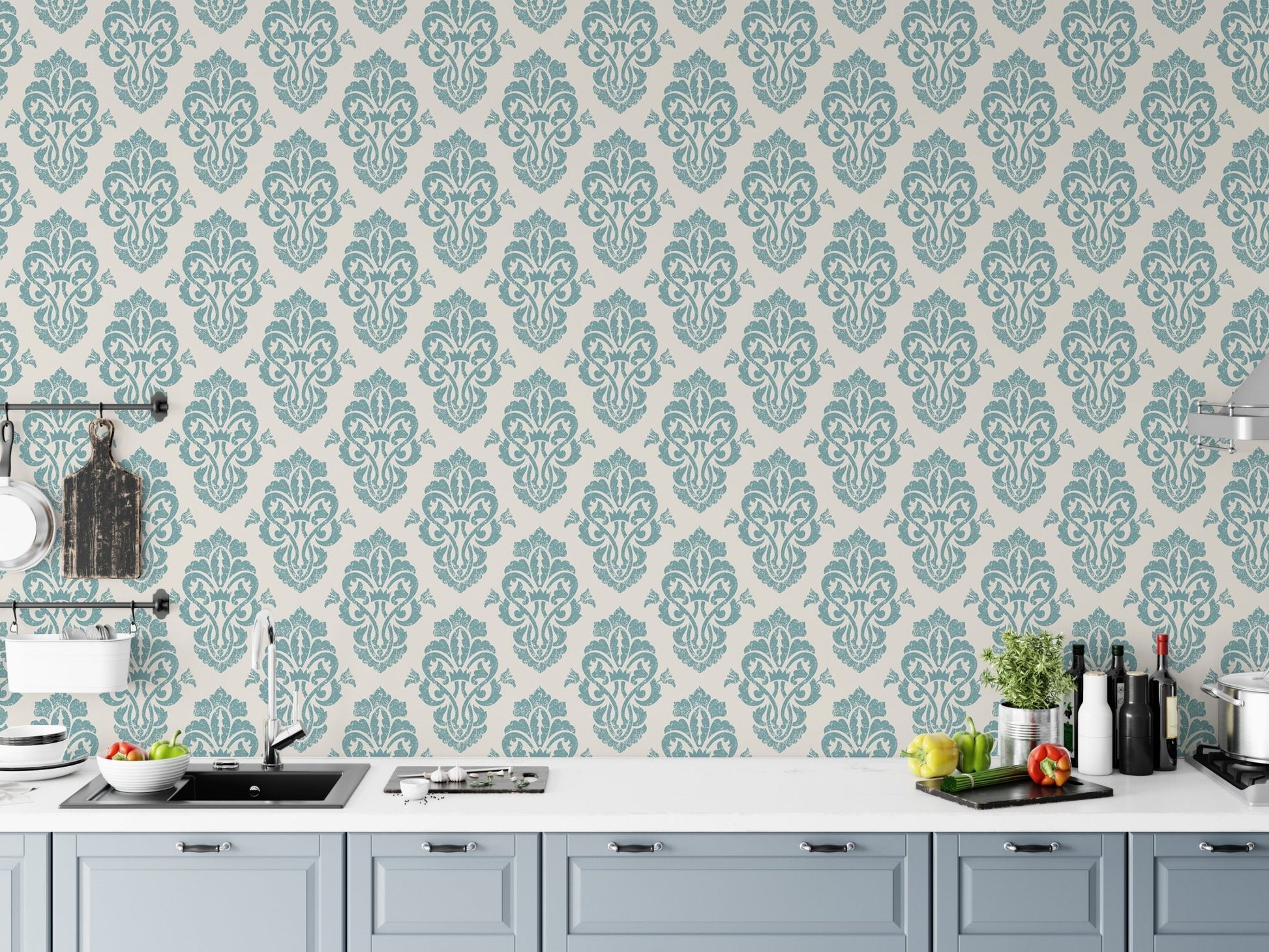 Teal and white damask wallpaper in a modern kitchen behind white cabinets.