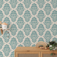 Ornamental damask wallpaper behind a wooden console table with plants.