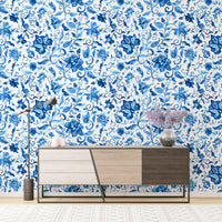 Sideboard against blue paisley floral pattern wallpaper in a bright room.