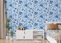 Minimalist bedroom wallpaper with blue floral designs behind white media console.