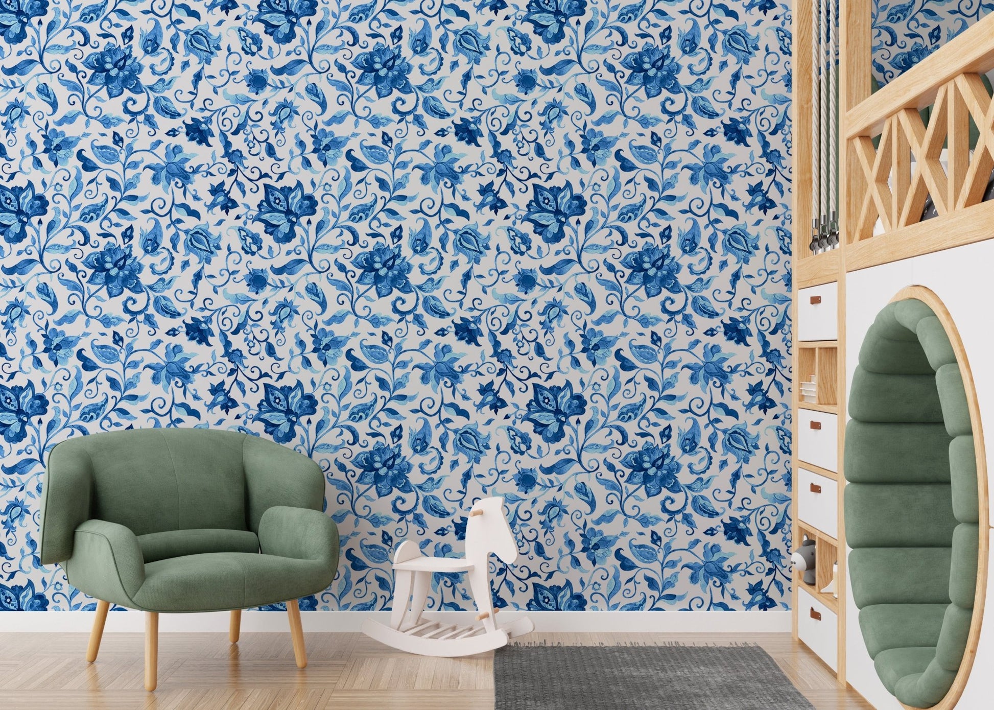 Green velvet chair in a room with blue watercolor floral wallpaper.
