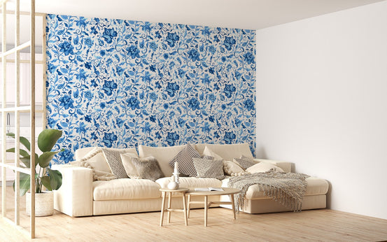 Large living room wallpaper with blue floral pattern behind a beige sofa.