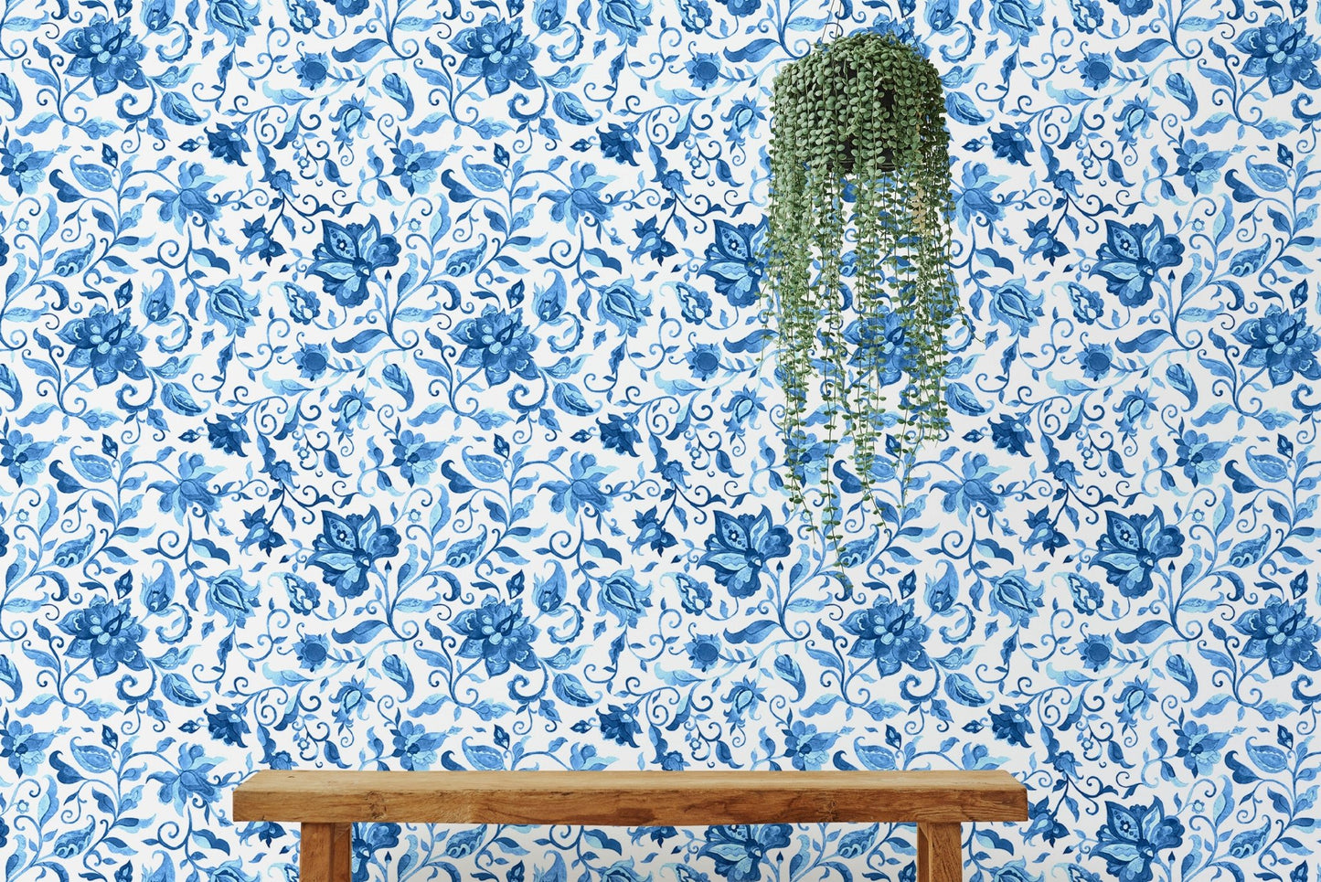 Hanging plant against blue paisley floral pattern wallpaper section.