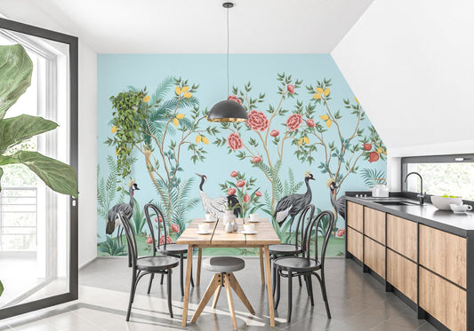 Dining area with wooden table against blue bird themed wall mural.