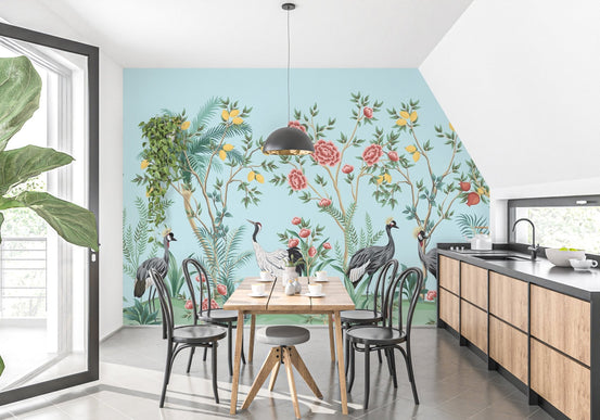 Dining area with wooden table against blue bird themed wall mural.